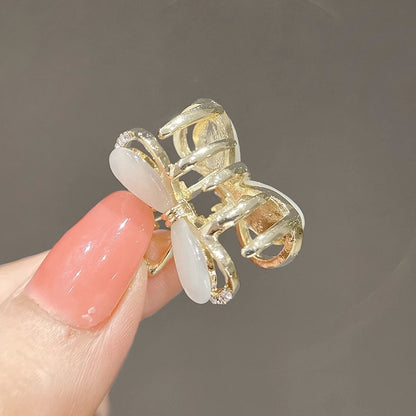 Black bow mini claw clip shown from an angled view