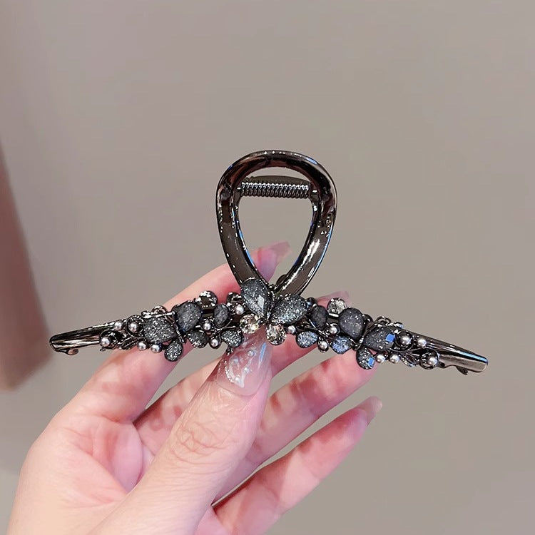 Large Black Butterfly Hair Claw Clip with Pearl Detail front view in hand