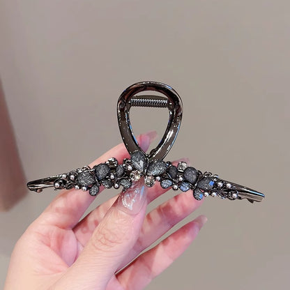 Large Black Butterfly Hair Claw Clip with Pearl Detail front view in hand